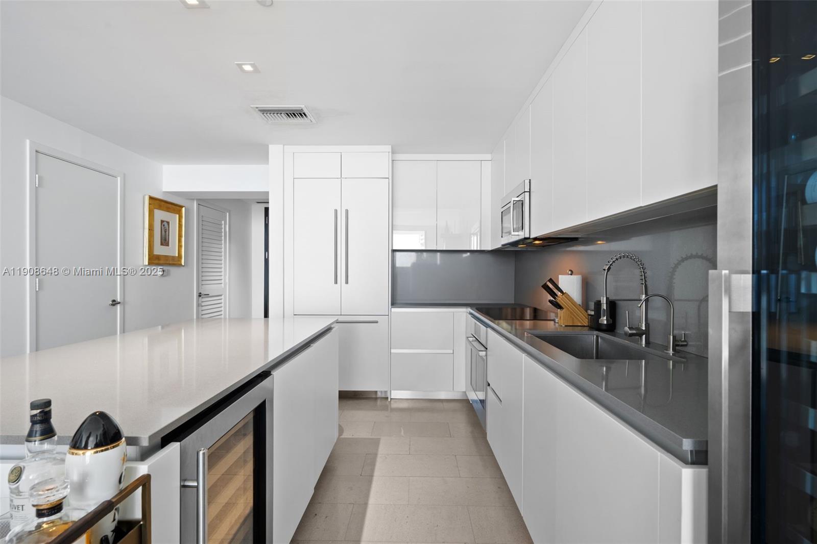 68 Southeast 6th Street, Unit 2505 Miami, FL 33131 - Photo 4 of 18 a kitchen with granite countertop a sink and cabinets