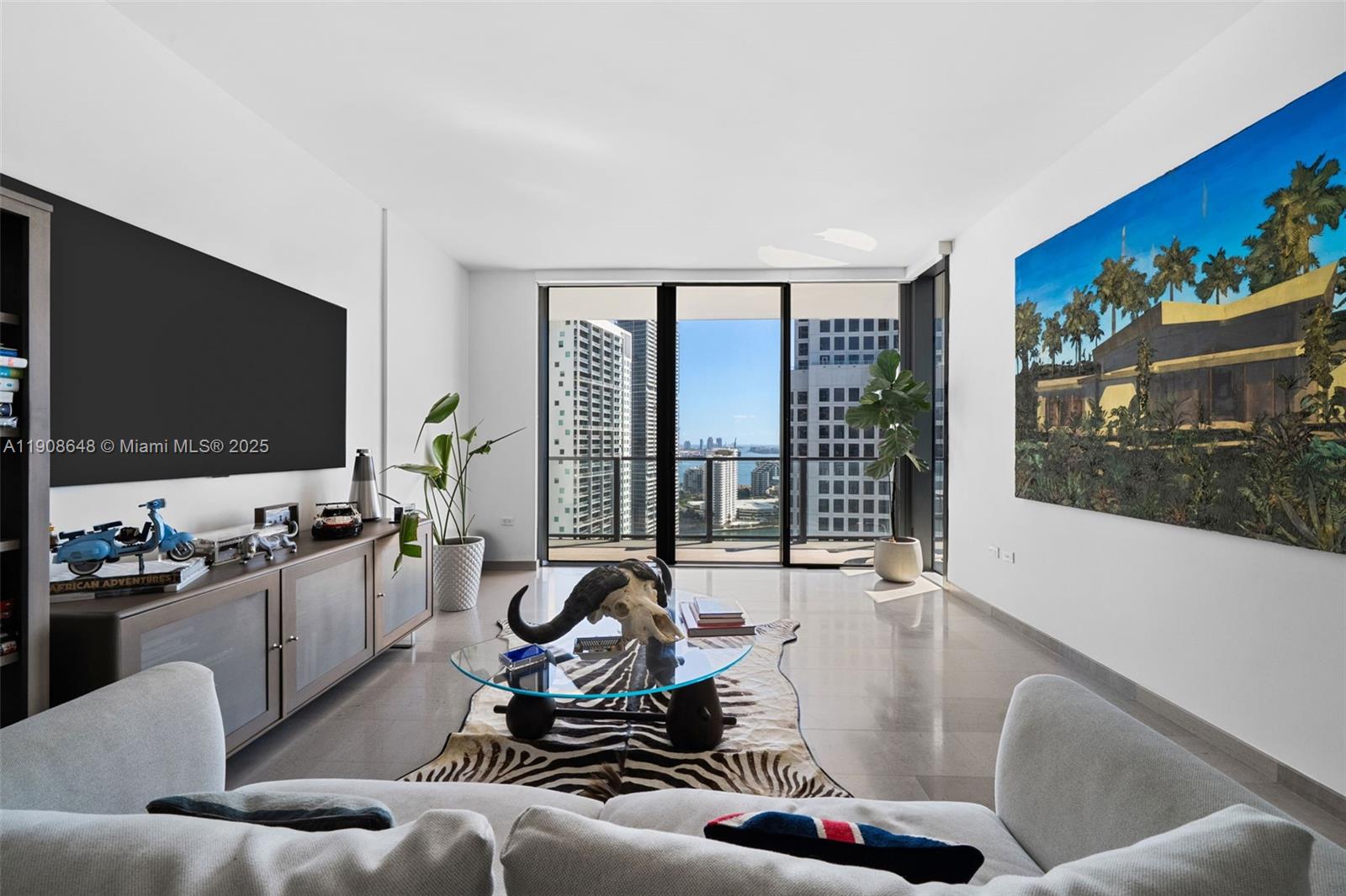 68 Southeast 6th Street, Unit 2505 Miami, FL 33131 - Photo 6 of 18 a living room with furniture and a flat screen tv