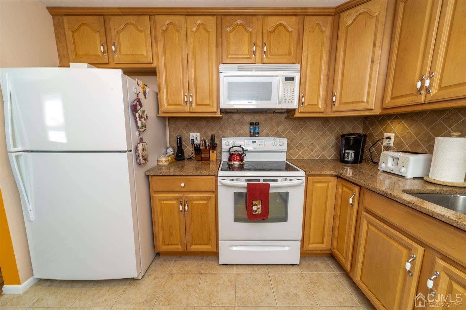 142 Weiss Terrace Raritan, NJ 08869 - Photo 11 of 29 a kitchen with stainless steel appliances granite countertop a refrigerator sink stove and microwave