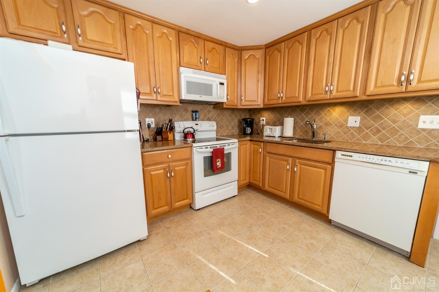 142 Weiss Terrace Raritan, NJ 08869 - Photo 12 of 29 a kitchen with stainless steel appliances granite countertop a refrigerator a stove a sink and white cabinets