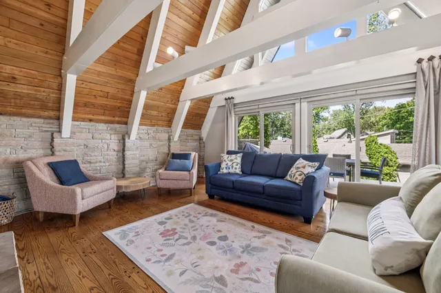 a living room with furniture a flat tv screen and large window