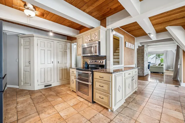 a view of a hallway with wooden floor and a chandelier