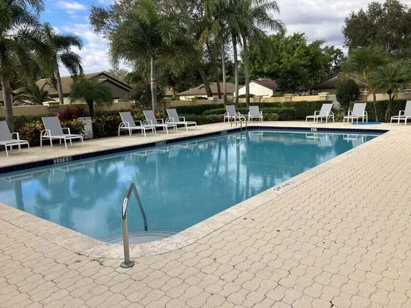 a view of a swimming pool with a chair and tables