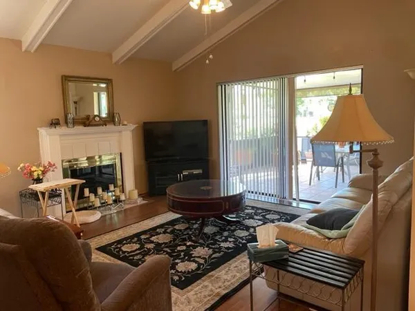 a living room with furniture a flat screen tv and a floor to ceiling window