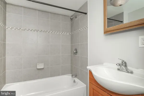 a white bath tub sitting next to a white sink and a shower