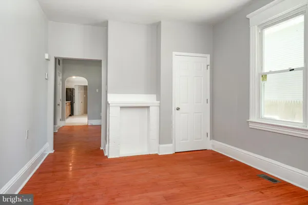 a view of hallway with wooden floor and a window