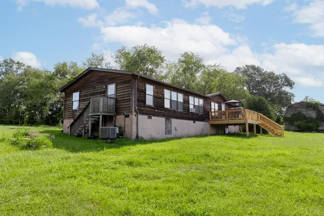 a view of a house with a yard and deck