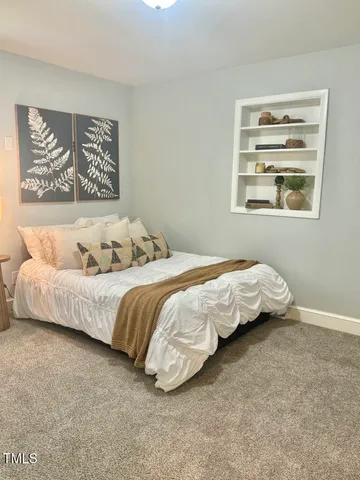 a bedroom with a bed and a painting on the wall