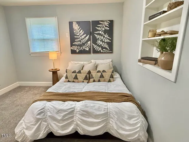 a bedroom with a bed and painting on the wall