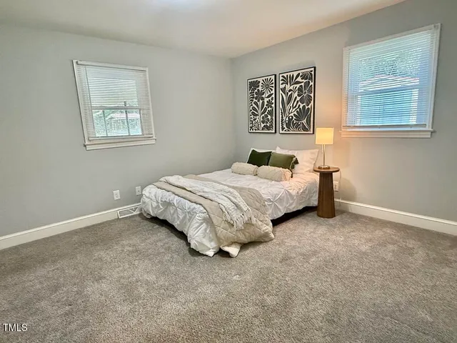 a spacious bedroom with a bed and a window