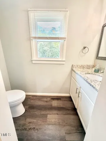 a bathroom with a sink a toilet and a window