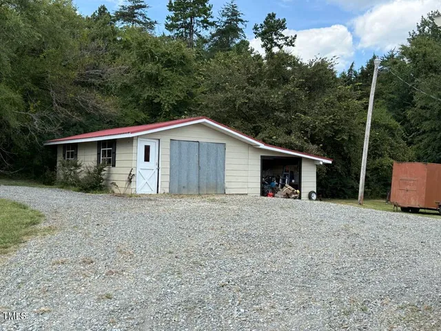 a view of a house with a backyard and bushes