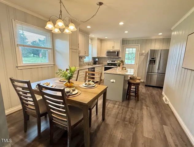 a view of a dining room with furniture and chandelier