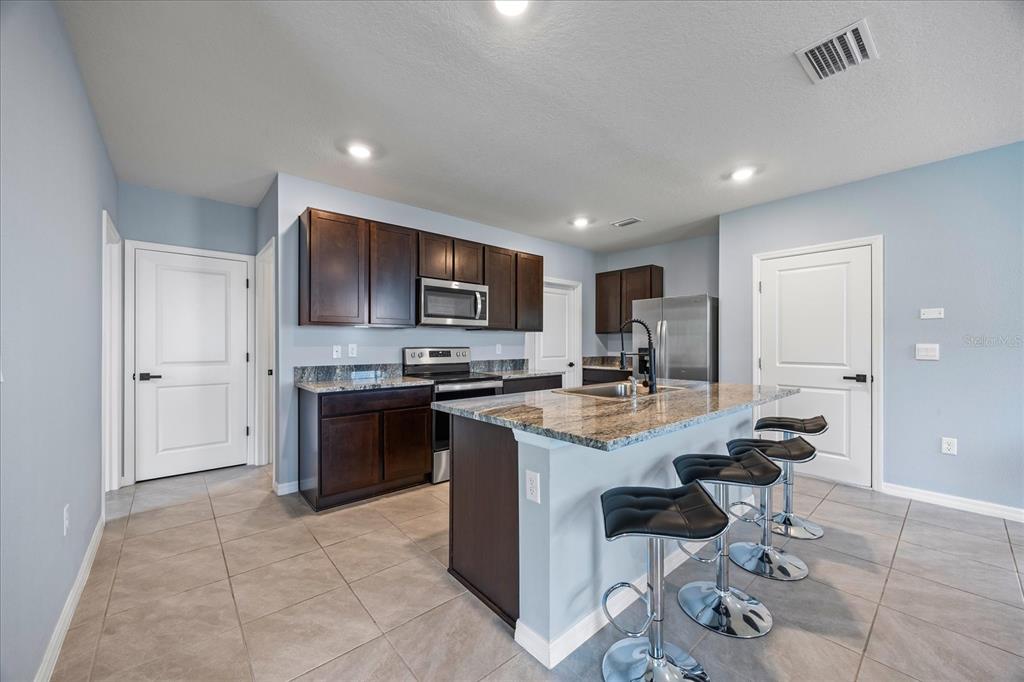 1680 Hazy Sea Drive Plant City, FL 33565 - Photo 14 of 49 a kitchen with a sink a counter top space appliances and cabinets