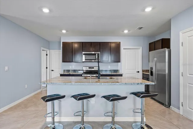 a kitchen with stainless steel appliances granite countertop a refrigerator sink and stove