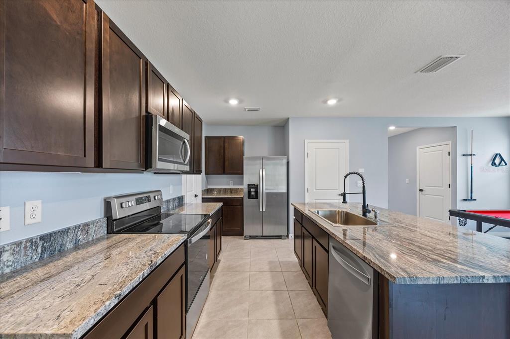 1680 Hazy Sea Drive Plant City, FL 33565 - Photo 16 of 49 a kitchen with stainless steel appliances granite countertop counter space a sink and cabinets