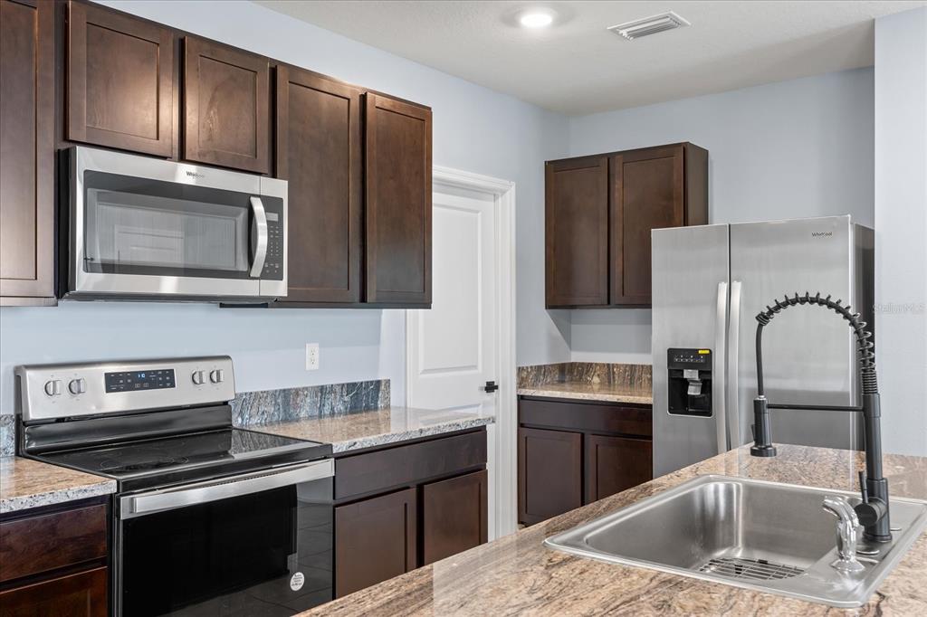 1680 Hazy Sea Drive Plant City, FL 33565 - Photo 17 of 49 a kitchen with stainless steel appliances granite countertop a refrigerator sink and stove