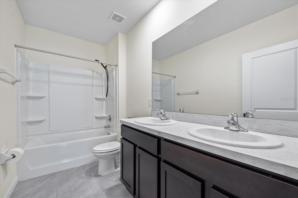 1680 Hazy Sea Drive Plant City, FL 33565 - Photo 34 of 49 a bathroom with a granite countertop sink toilet and shower