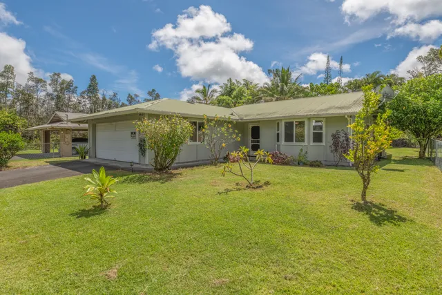 a view of a house with a backyard and a tree