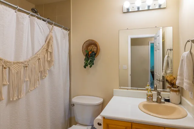 a bathroom with a sink a toilet and a mirror