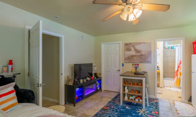 a bedroom with furniture a flat screen tv and a window