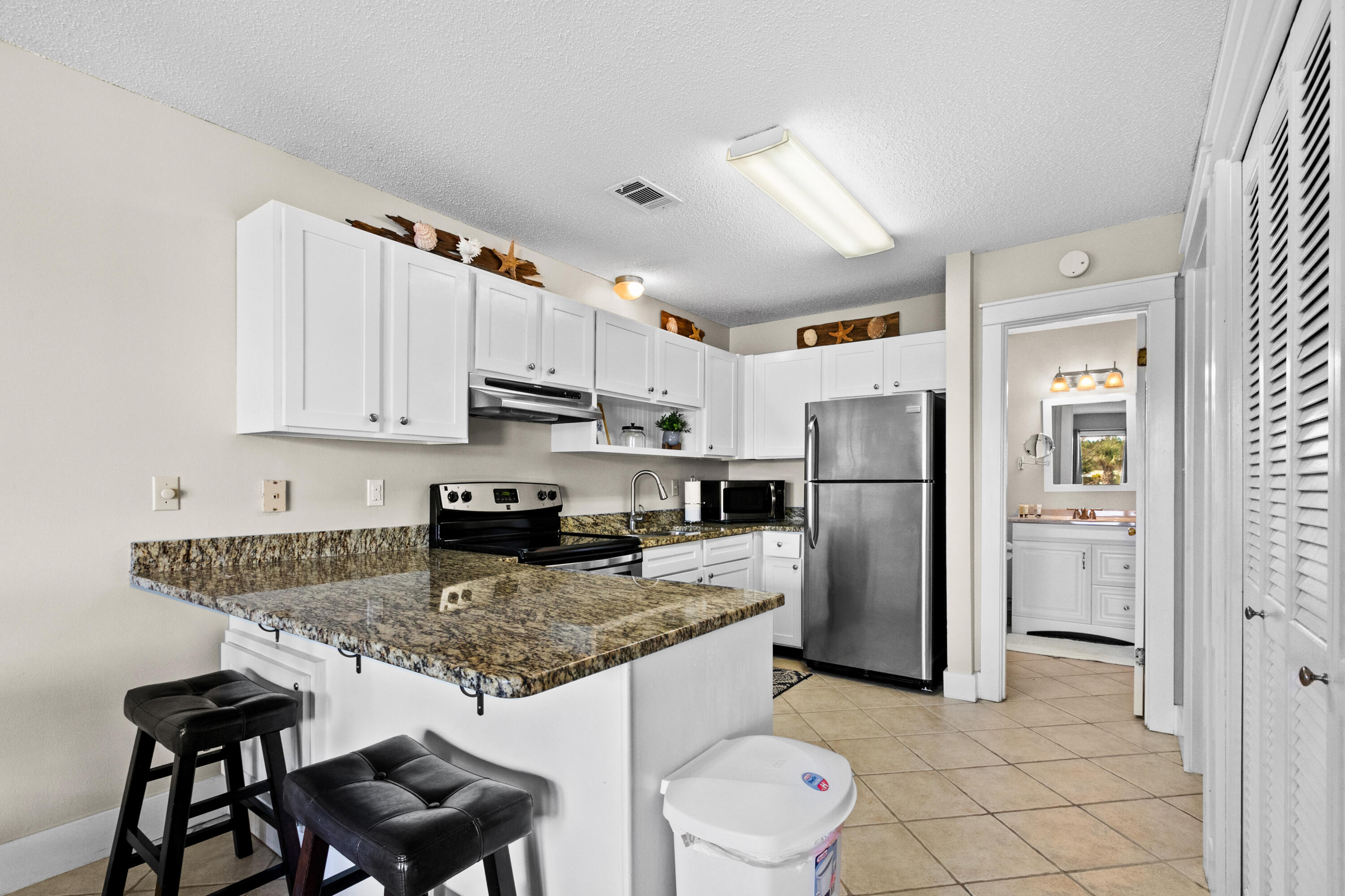 3799 East County Highway 30A, Unit F2 Santa Rosa Beach, FL 32459 - Photo 11 of 21 a kitchen with stainless steel appliances granite countertop a refrigerator sink and cabinets