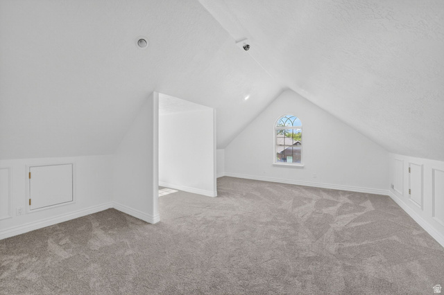 883 East 700 South Springville, UT 84663 - Photo 25 of 59 Spacious upper-level room featuring sloped ceilings, light gray carpeting, and an arched window with decorative mullions