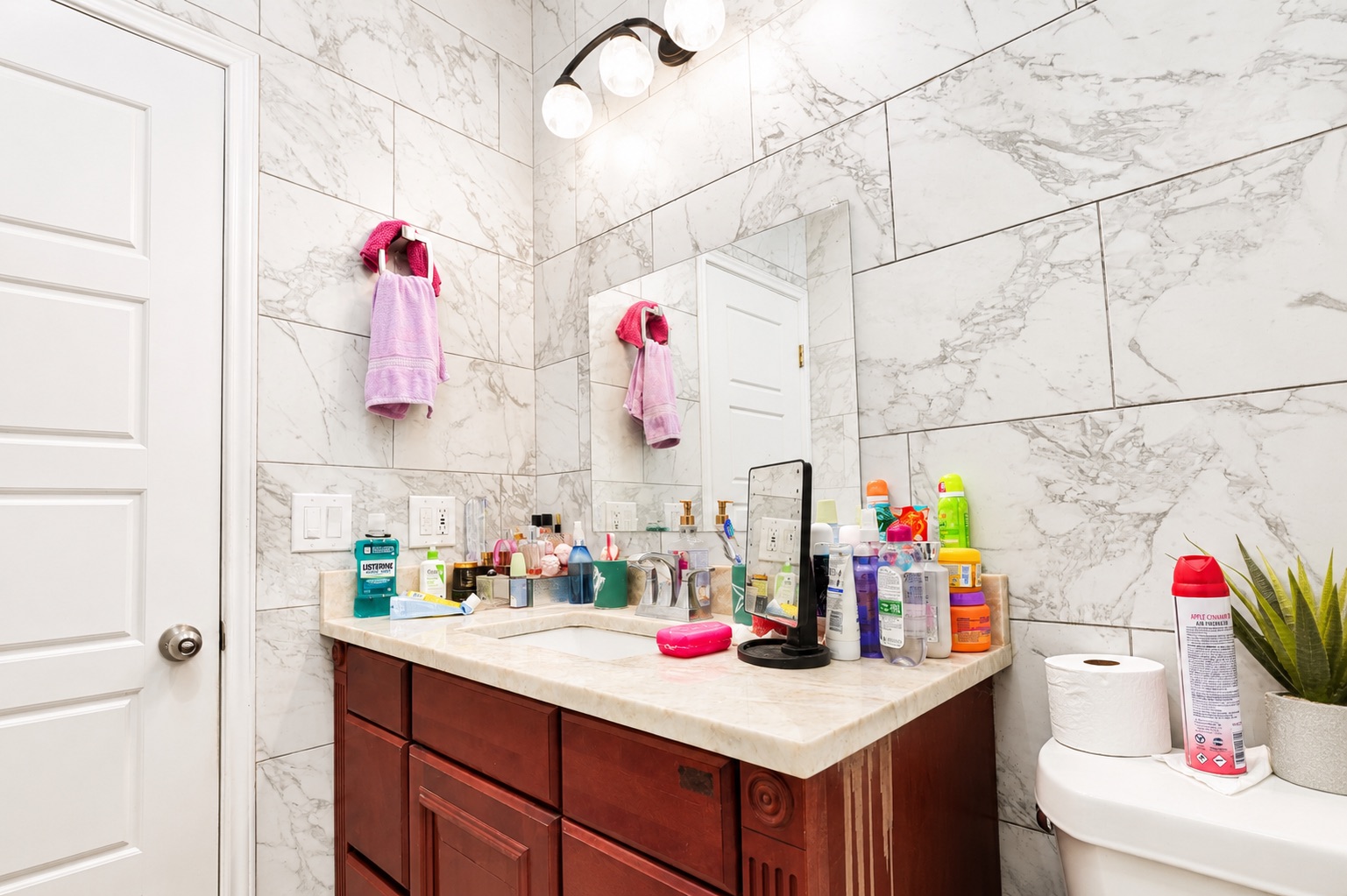 130 Los Arcos Road Elgin, TX 78621 - Photo 9 of 39 Marble-look tile walls elevate this functional bathroom with a classic, clean aesthetic.