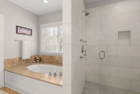 a bathroom with a granite countertop sink a window and shower