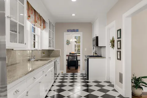 a kitchen with a sink a refrigerator and cabinets