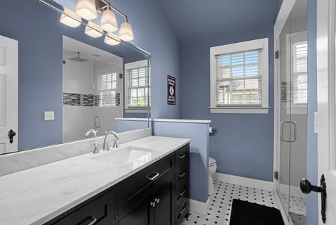 a bathroom with a granite countertop sink a mirror and a shower