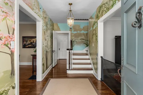 a view of a hallway with wooden floor and staircase