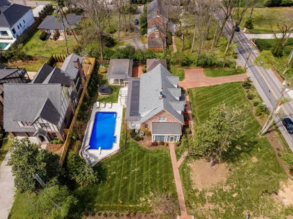an aerial view of residential houses with outdoor space and trees