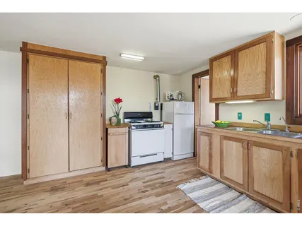 a kitchen with granite countertop a refrigerator stove top oven and sink