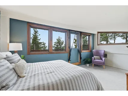a bedroom with a bed and large windows