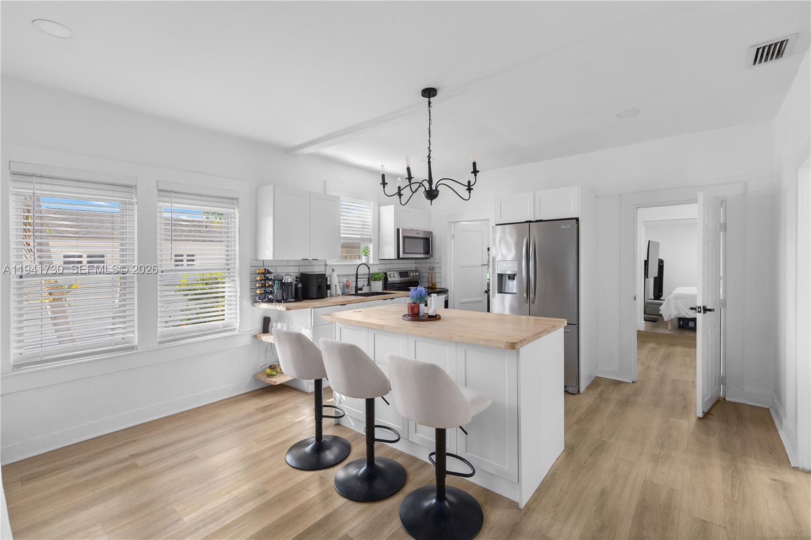 2811 Southwest 17th Street Miami, FL 33145 - Photo 11 of 36 a view of a dining room and livingroom with furniture wooden floor a chandelier