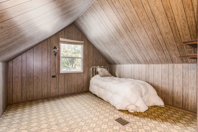a view of a roof deck with couches and wooden fence