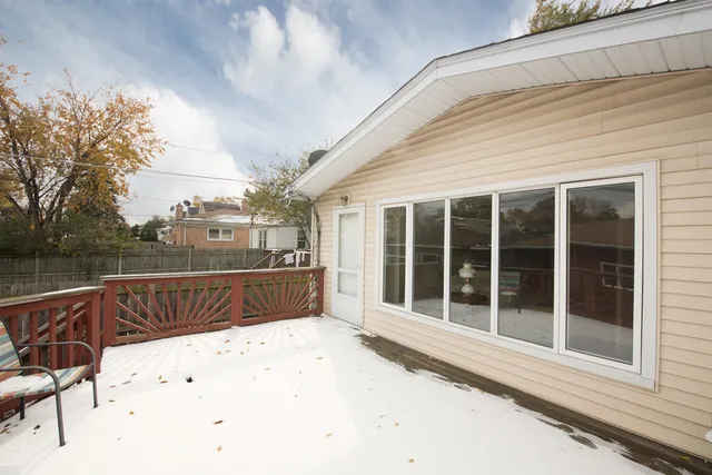 a view of a house with a wooden deck and a yard