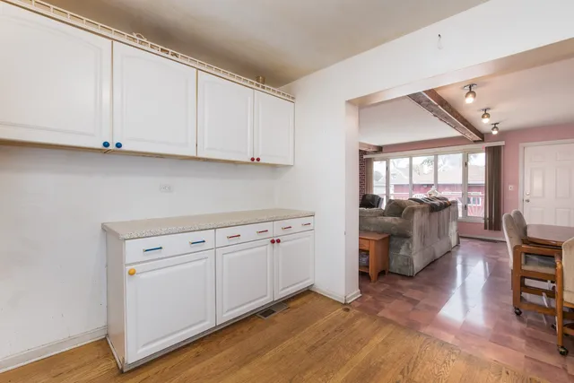 a kitchen with cabinets and wooden floor