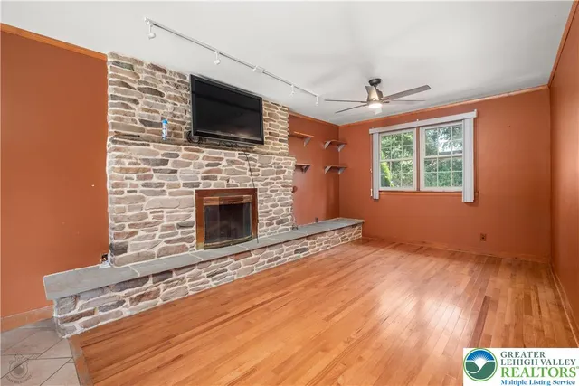 a view of an empty room with a fireplace and a window