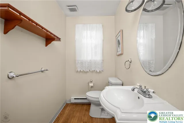 a bathroom with a sink a toilet and a mirror