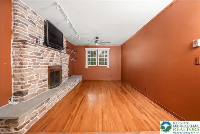 a view of a livingroom with wooden floor and a fireplace