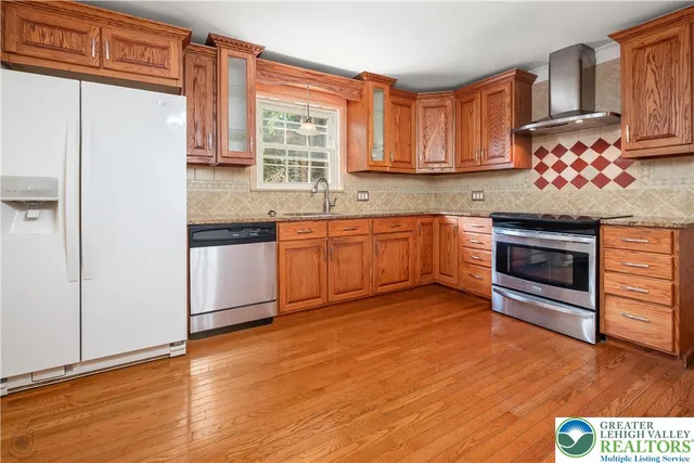 a kitchen with stainless steel appliances granite countertop a stove a sink and a refrigerator