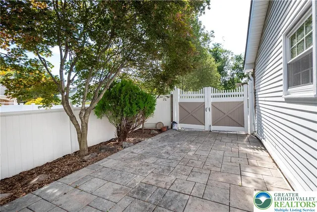 a backyard of a house with large trees and brick walls