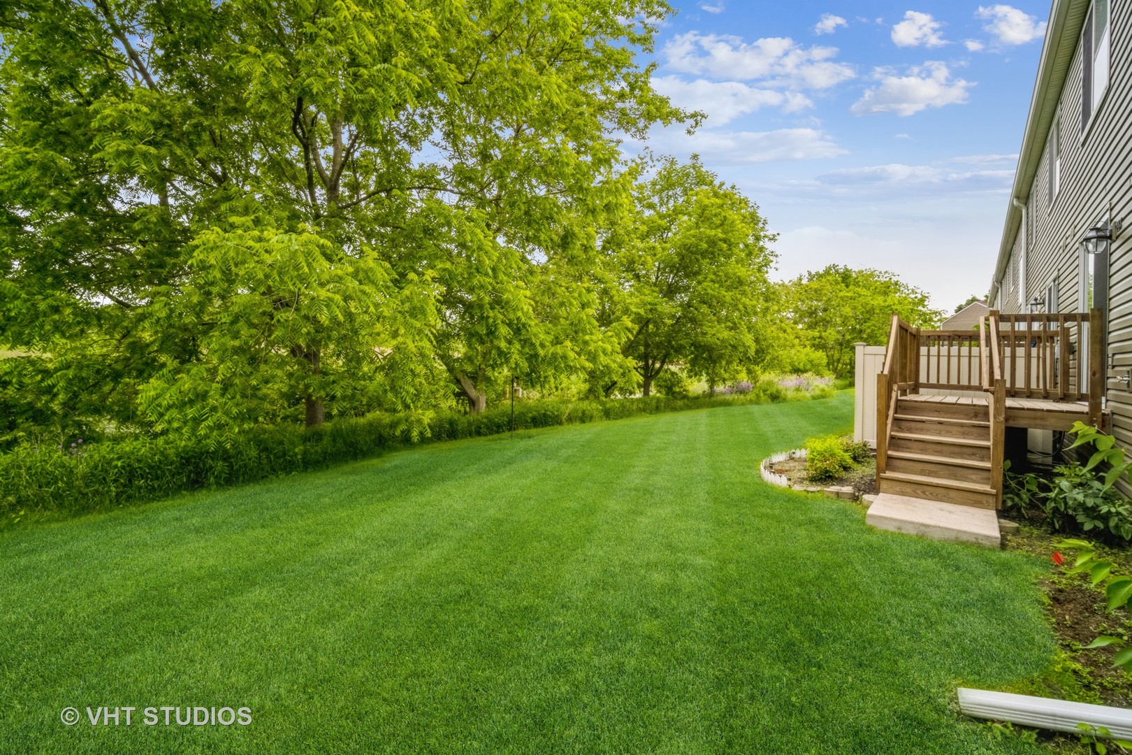 417 Locksley Drive Streamwood, IL 60107 - Photo 4 of 25 a view of a green field with wooden fence