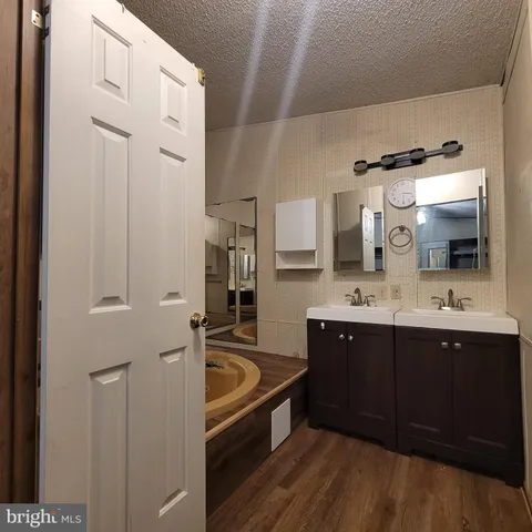 a spacious bathroom with a tub sink and mirror