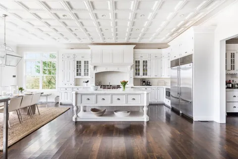 a large white kitchen with sink stove and refrigerator