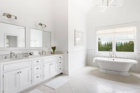 a spacious bathroom with a double vanity sink a mirror and a bathtub