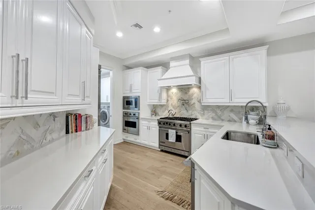 a kitchen with granite countertop a sink stainless steel appliances and cabinets