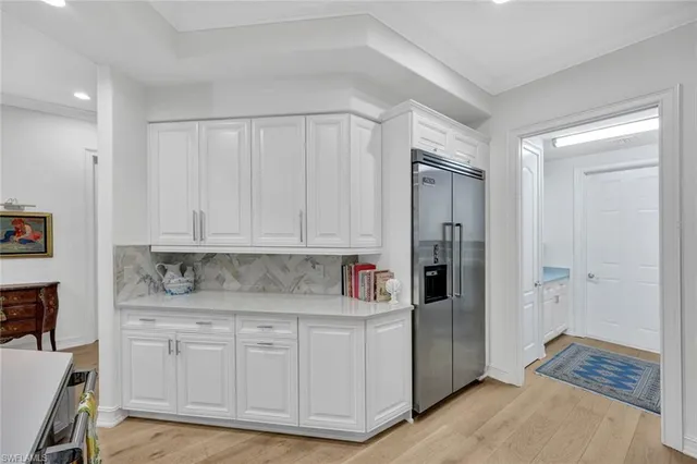 a kitchen with white cabinets and refrigerator